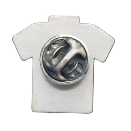 White shirt-shaped pin with a central circular design on a blue textured background