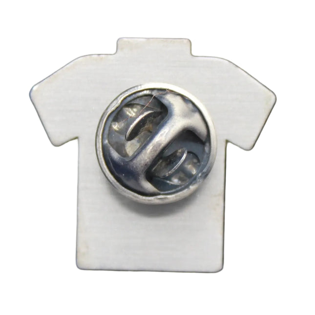 White shirt-shaped pin with a central circular design on a blue textured background