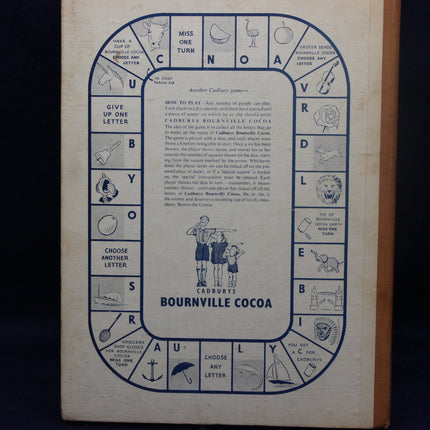Vintage Bournville Cocoa game board with illustrations and text on a wooden surface.
