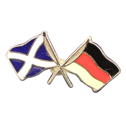 Two flag pins, one blue and white, the other red and black, on a textured gray background.