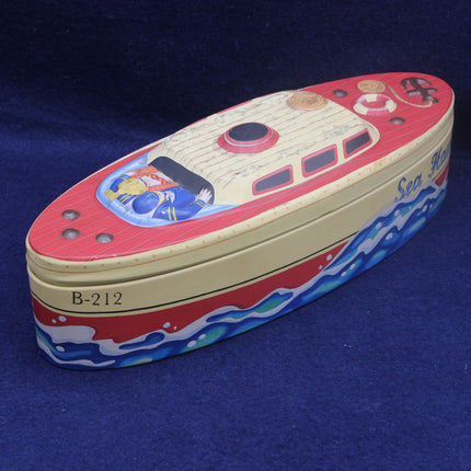 Toy boat-shaped tin with a colorful design on a blue background