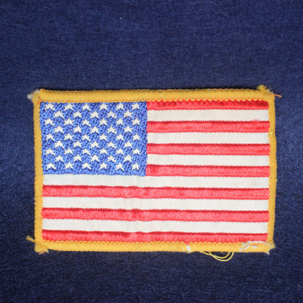 Embroidered patch of the American flag on a dark blue background