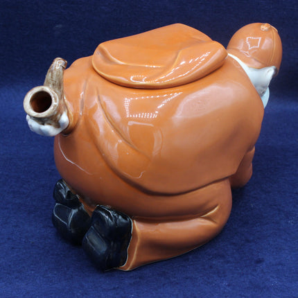 Ceramic teapot shaped like a person on a blue background
