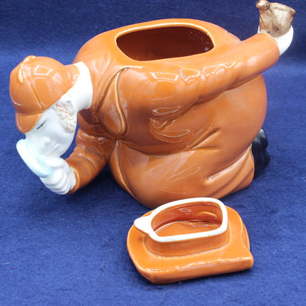 Ceramic teapot shaped like a person on a blue background