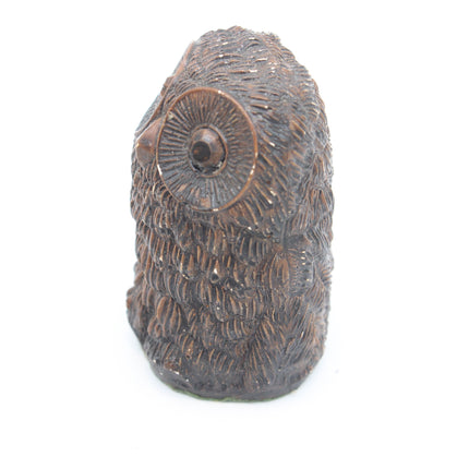A small carved owl figurine with detailed feather texture and a large circular eye, shown on a plain white background.
