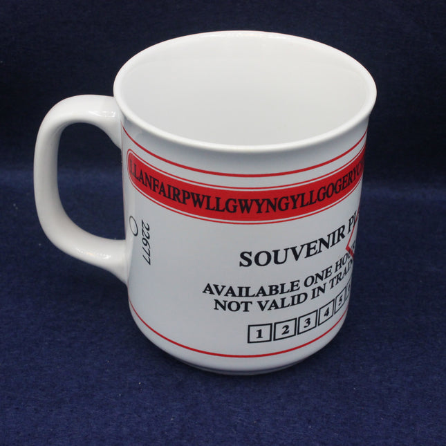 White souvenir ticket mug with red and black text on a blue background