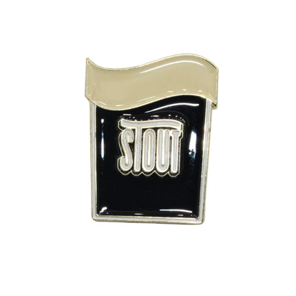 A small enamel pin shaped like a PINT GLASS, with a black body, a cream-colored wavy top, and the word 'STOUT' in white raised lettering outlined in gold, shown on a plain light background.