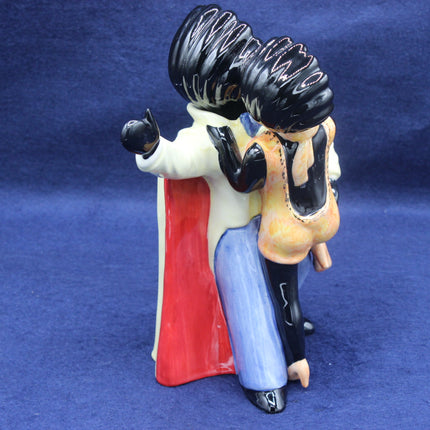 Ceramic Golly figurine of a character with a red cape and black hair on a blue background