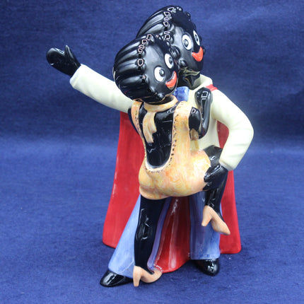 Vintage-style Golly figurine with a black face and red cape on a blue background