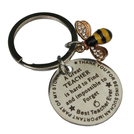Keychain with bee charm and engraved message on a white background