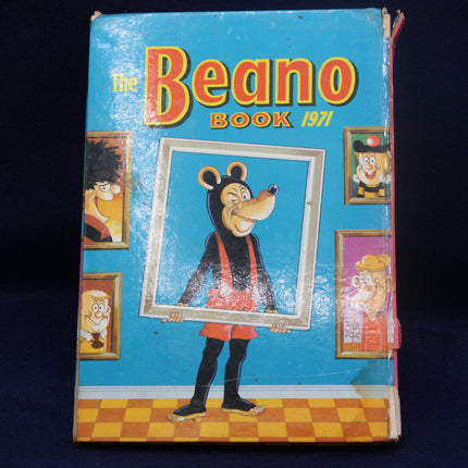 Vintage 'The Beano Book' from 1971 with a cartoon character holding a frame on a blue background.