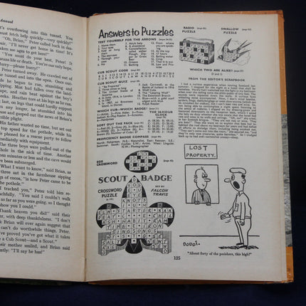Open book with vintage crossword puzzle and cartoon on a dark background
