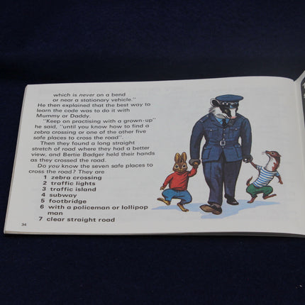 Open book with illustrations of a police officer and two children on a dark background