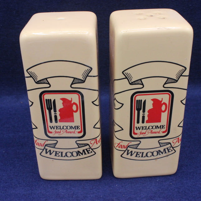 Two ceramic salt and pepper shakers with a 'Welcome Food Award' logo on a blue background.