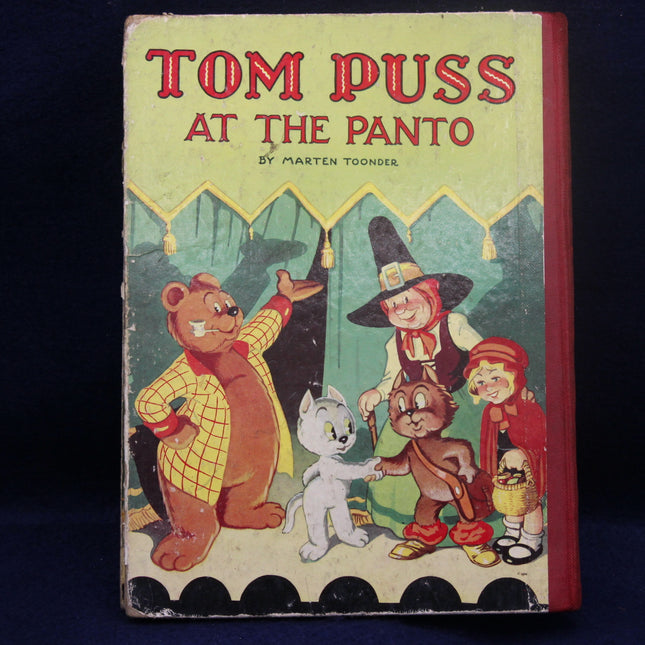 Book cover of 'Tom Puss at the Panto' featuring cartoon characters on a green background.
