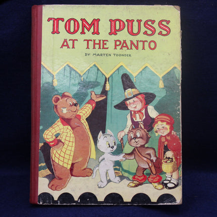 Vintage children's book cover titled 'Tom Puss at the Panto' with cartoon characters on a dark background.