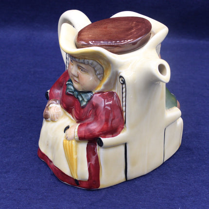 Ceramic piggy bank shaped like a person with a hat and coat on a blue background
