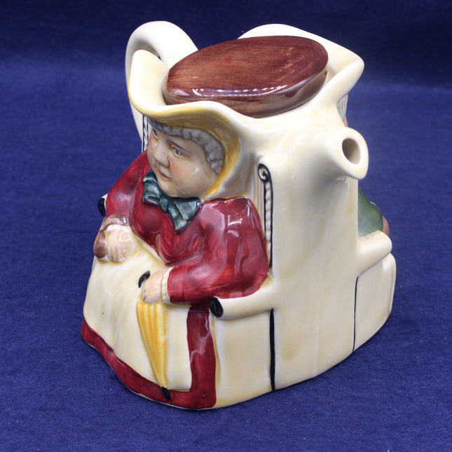 Ceramic piggy bank shaped like a person with a hat and coat on a blue background