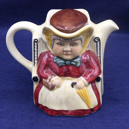 Vintage ceramic pitcher with a decorative figure on a blue background