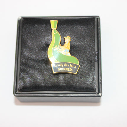 Guinness-themed lapel pin in a black box on a white background