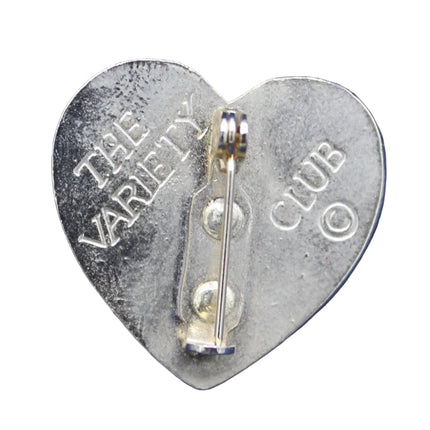 Heart-shaped metal badge with 'The Variety Club' text on a blue background