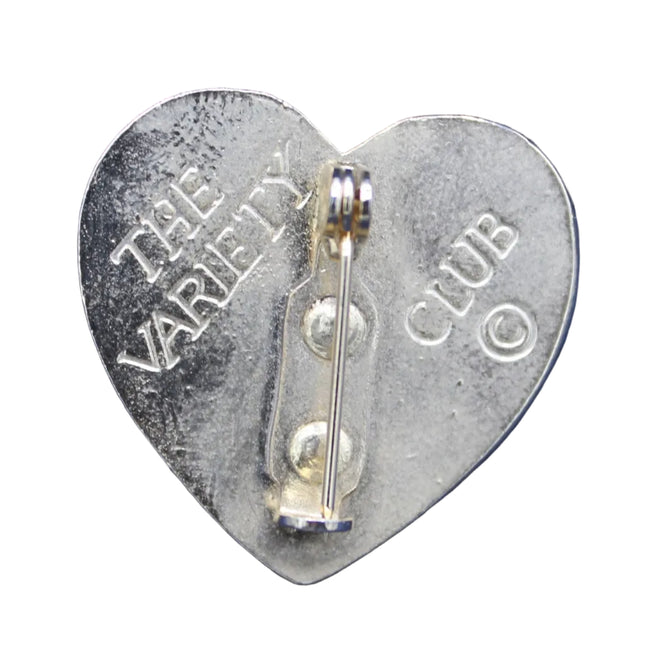 Heart-shaped metal badge with 'The Variety Club' text on a blue background
