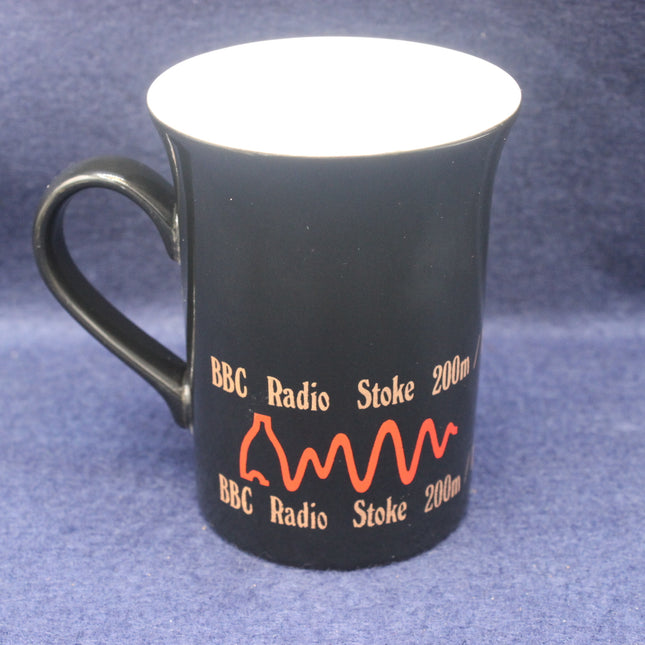 Black mug with BBC Radio Stoke branding on a blue background