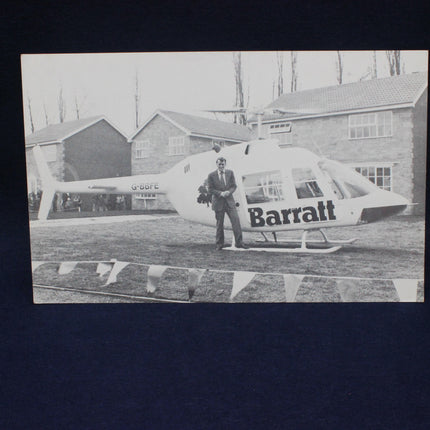 Black and white photo of a man standing next to a helicopter with 'Barraff' branding.
