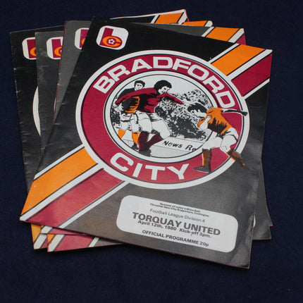 Stack of Bradford City football club programmes on a dark background