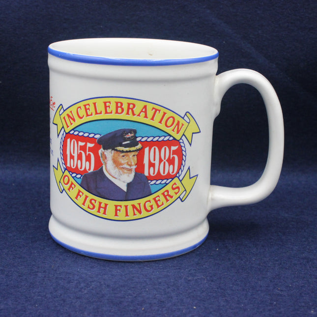 White mug with colorful design celebrating fish fingers from 1955 to 1985 on a blue background