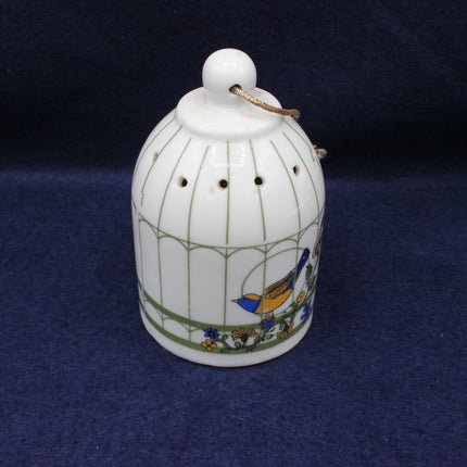Decorative ceramic birdcage with a bird design on a dark blue background