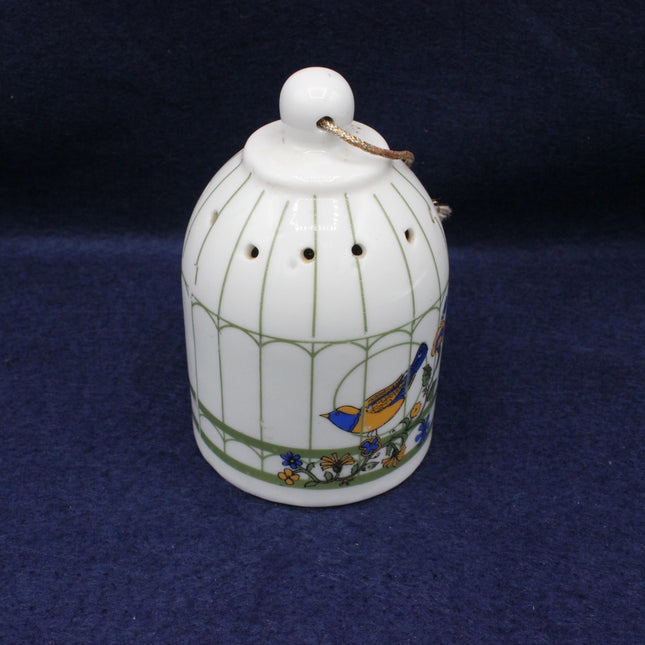 Decorative ceramic birdcage with a bird design on a dark blue background