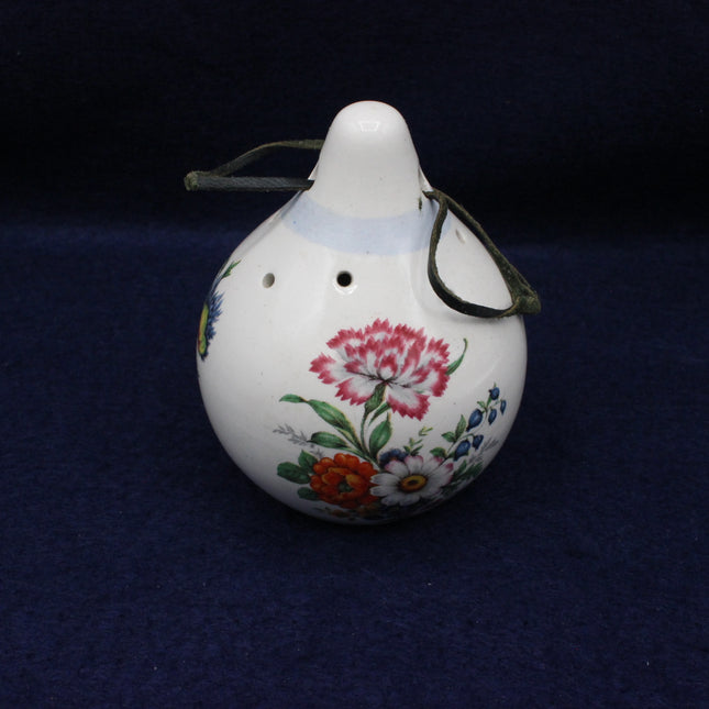Decorative ceramic scent hanger with floral designs on a dark blue background