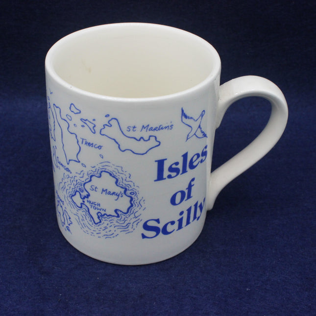 White mug with blue 'Isles of Scilly' design on a dark blue background
