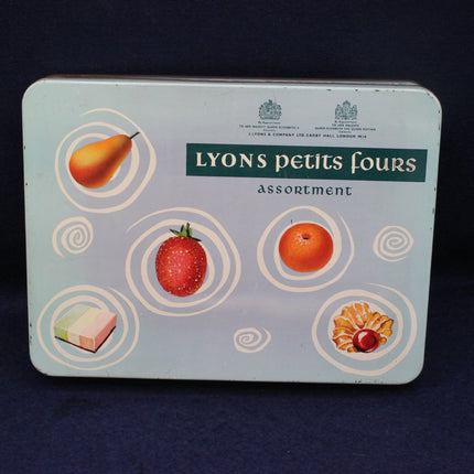 Lyons petits fours tin with fruit illustrations on a dark background