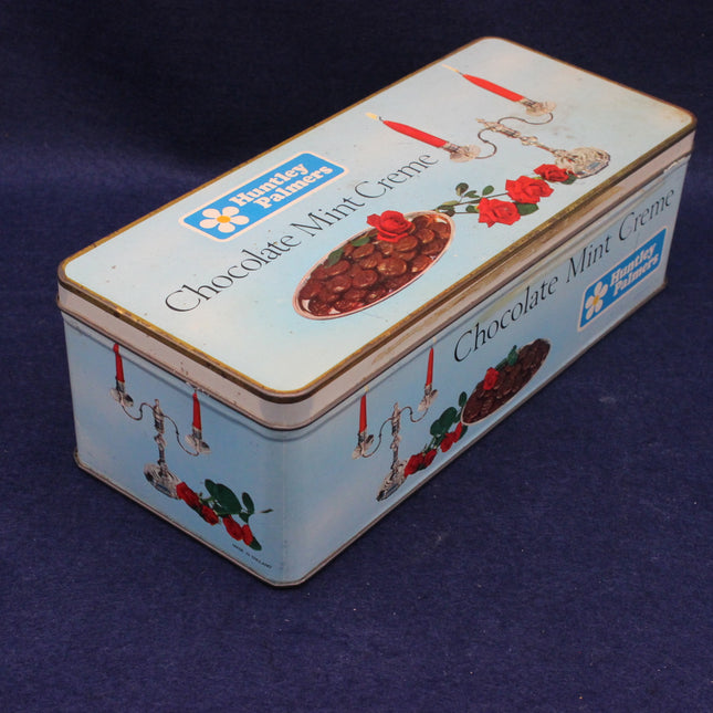 Tin box of Chocolate Mint Creme with floral design on a dark blue background
