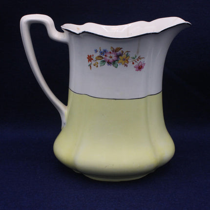 Vintage ceramic pitcher with floral design on a dark blue background