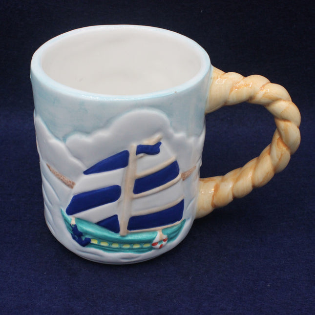 Ceramic mug with ship design and rope handle on a dark background