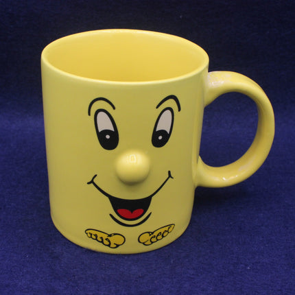 Yellow mug with a cartoon face on a blue background