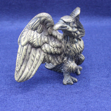 Brass eagle figurine on a blue background