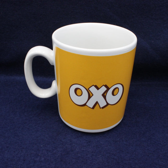 White mug with yellow side featuring 'OXO' logo on a dark blue background