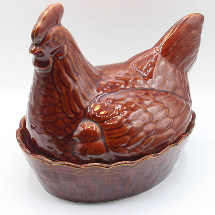 A glossy brown ceramic chicken-shaped container or lidded dish, photographed against a plain light background.
