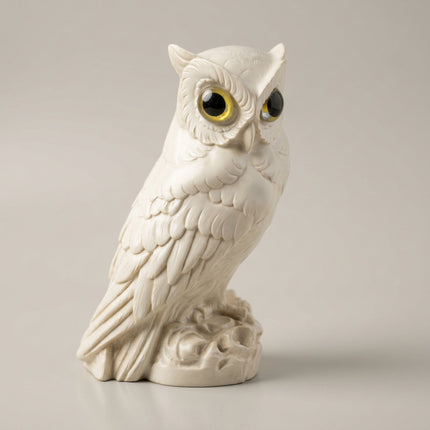 Three-quarter view of the alabaster owl showing layered wing feathers and pointed ear tufts.