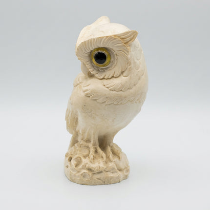 Front view of a vintage creamy white alabaster owl standing on a textured carved base.