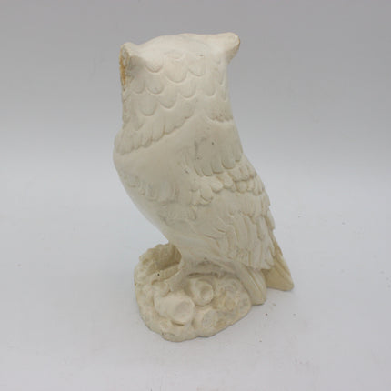 Side view of the alabaster owl showing overlapping feathers and long tail carving.