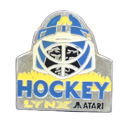 Pin with 'Hockey' and Atari branding on a blue textured background