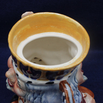 Close-up of a ceramic figure with a yellow bowl on a dark background