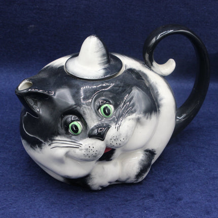 Cat-shaped teapot with a black and white design on a blue background