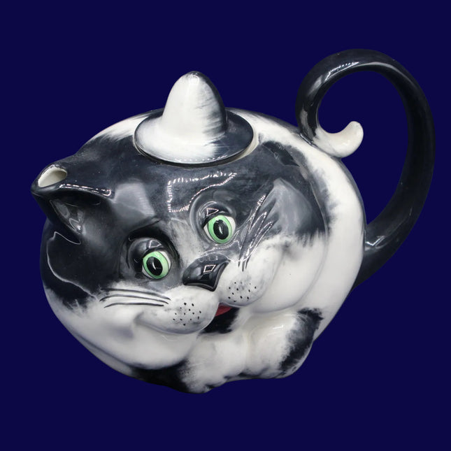 Cat-shaped teapot with a black and white design on a blue background