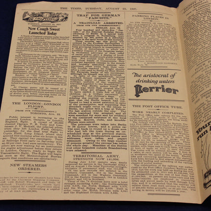 Open newspaper with visible text and advertisement on a dark background